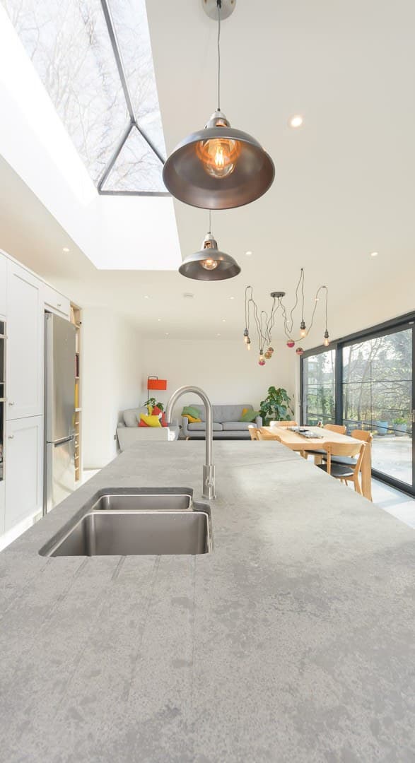 Long grey worktop with an inset sink under pendant lights